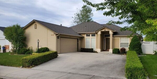 Stroll up to the front entrance, flanked by two windows, and enter a cozy home with a garage and beautifully manicured lawns.