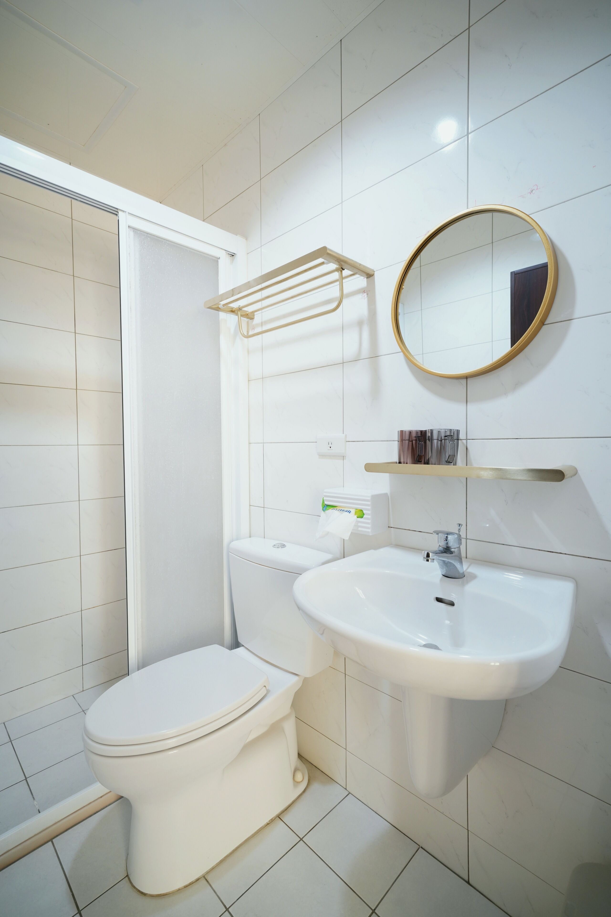 Un baño con inodoro, lavamanos y zona de ducha.