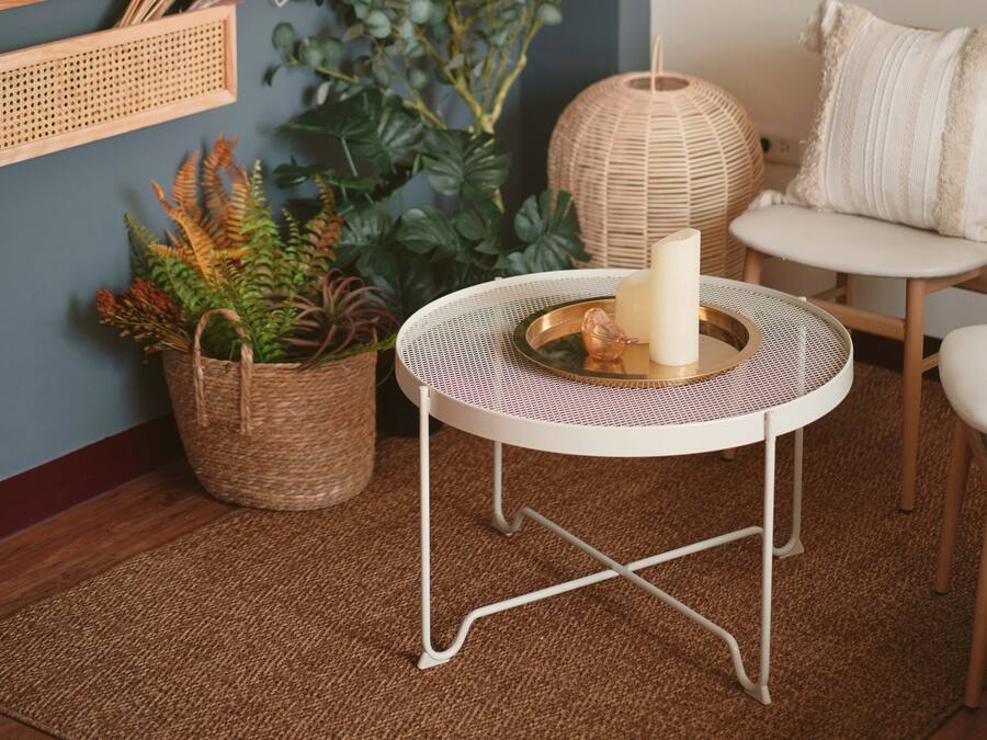 A cozy room with a round table, wicker baskets, and a macramé wall hanging.