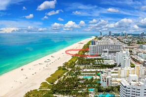 A coastal cityscape with a beach, high-rise buildings, and a clear blue sky. - Beachfront apartment with Ocean View (Miami Beach)