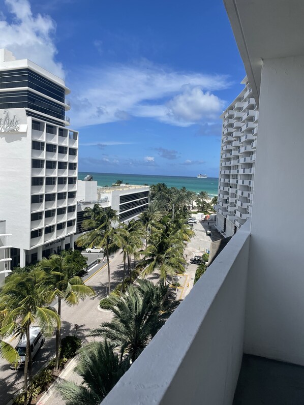 A view of a hotel with a pool area, palm trees, and a clear blue sky. - Beachfront apartment with Ocean View (Miami Beach)