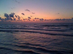 Ein Sonnenuntergang über dem Meer mit Wellen.