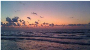 A sunset over the ocean with waves. - Island Oasis! 1st floor! One block to the beach! (Corpus Christi)