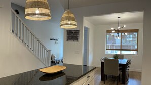 A kitchen with a black granite countertop, white cabinetry, and two hanging wicker chandeliers. - 5 Bedroom, 5 Minutes from Downtown (Flagstaff)