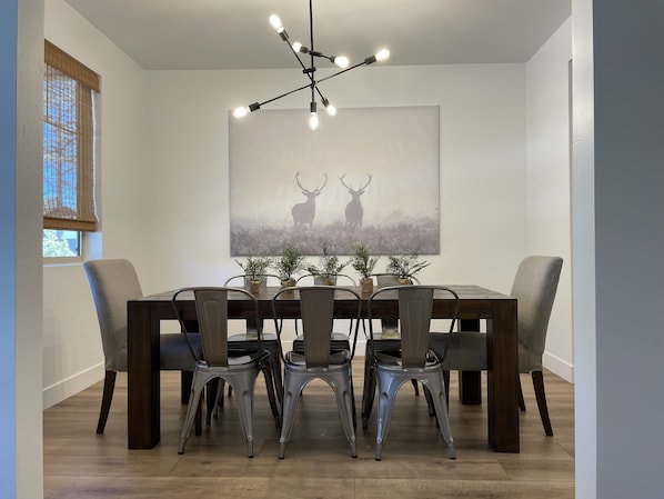 A dining area with a wooden table, metal chairs, and a modern chandelier. - 5 Bedroom, 5 Minutes from Downtown (Flagstaff)