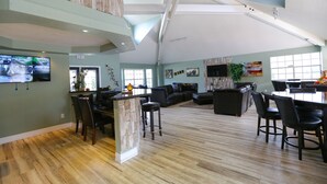 A spacious living area with a high ceiling, a stone accent wall, a dining area with a large table, and a seating arrangement. - ✪KING BED LARGE VILLA✪ Close to Disney & Outlets! (Kissimmee)