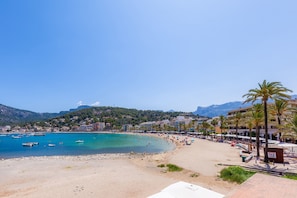 A beach with boats, a sandy shore, and buildings in the background. - Apartment 'Carla' with Mountain View, Wi-Fi and Air Conditioning (Puerto de Soller)
