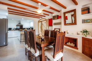 A dining area with a wooden table, chairs, a ceiling fan, and a fireplace. - Apartment 'Carla' with Mountain View, Wi-Fi and Air Conditioning (Puerto de Soller)