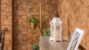 A stone wall, a hanging planter, a lantern, and a metal chair. - "Can Caragol" Holiday Apartment with Private Terrace, A/C & WiFi (Cala Rajada)