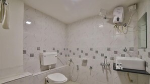 A bathroom with a toilet, bidet, and sink. - Hotel Maan Palace (Ahmedabad)