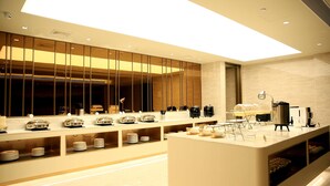 A modern hotel lobby with a long reception desk, a coffee machine, and a large window. - Ji Hotel (Lianyungang)