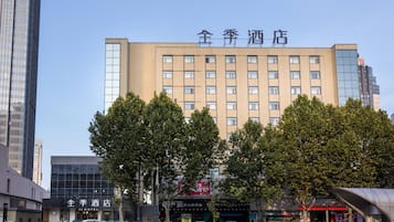 A hotel building with a modern facade, multiple windows, and a sign indicating it is a hotel.