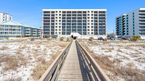 Un hôtel moderne à plusieurs étages, doté d’une galerie couverte et d’une plage de sable.