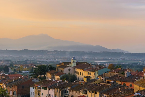Uma cidade com edifícios históricos, uma igreja importante e uma montanha ao fundo.