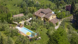 A villa with a swimming pool, surrounded by lush greenery and hilly terrain. - Casale Vittoria (Montopoli in Val d'Arno)