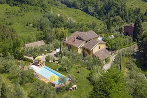 Uma villa com piscina, rodeada por vegetação exuberante e paisagem montanhosa.