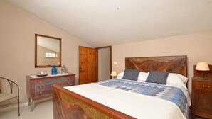 A bedroom with a wooden bed, a dresser, a mirror, and a nightstand. - Casale Vittoria (Montopoli in Val d'Arno)