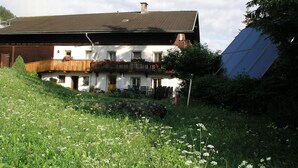 A two-story building with a balcony, a satellite dish, and a solar panel. - Cozy Angererhof: Near Drei Zinnen - Dolomites Apartment (4P) - ALPINE (Kartitsch)