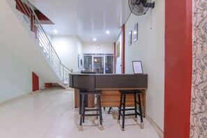 A modern kitchen with a wooden countertop and two stools. - Ratu Residence (Medan)