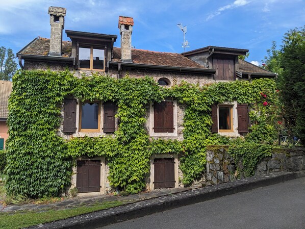 A two-story building with a stone facade partially covered in green ivy. - Charming house on the shores of Lake Geneva (Anthy-sur-Léman)
