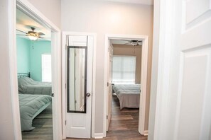 A hallway with two bedrooms, each with a bed and a ceiling fan. - Basic 4BR Home 15 Min Downtown ATL Sleeps 8+ (Atlanta)