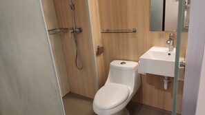 A small bathroom with a toilet, a sink, and a shower.