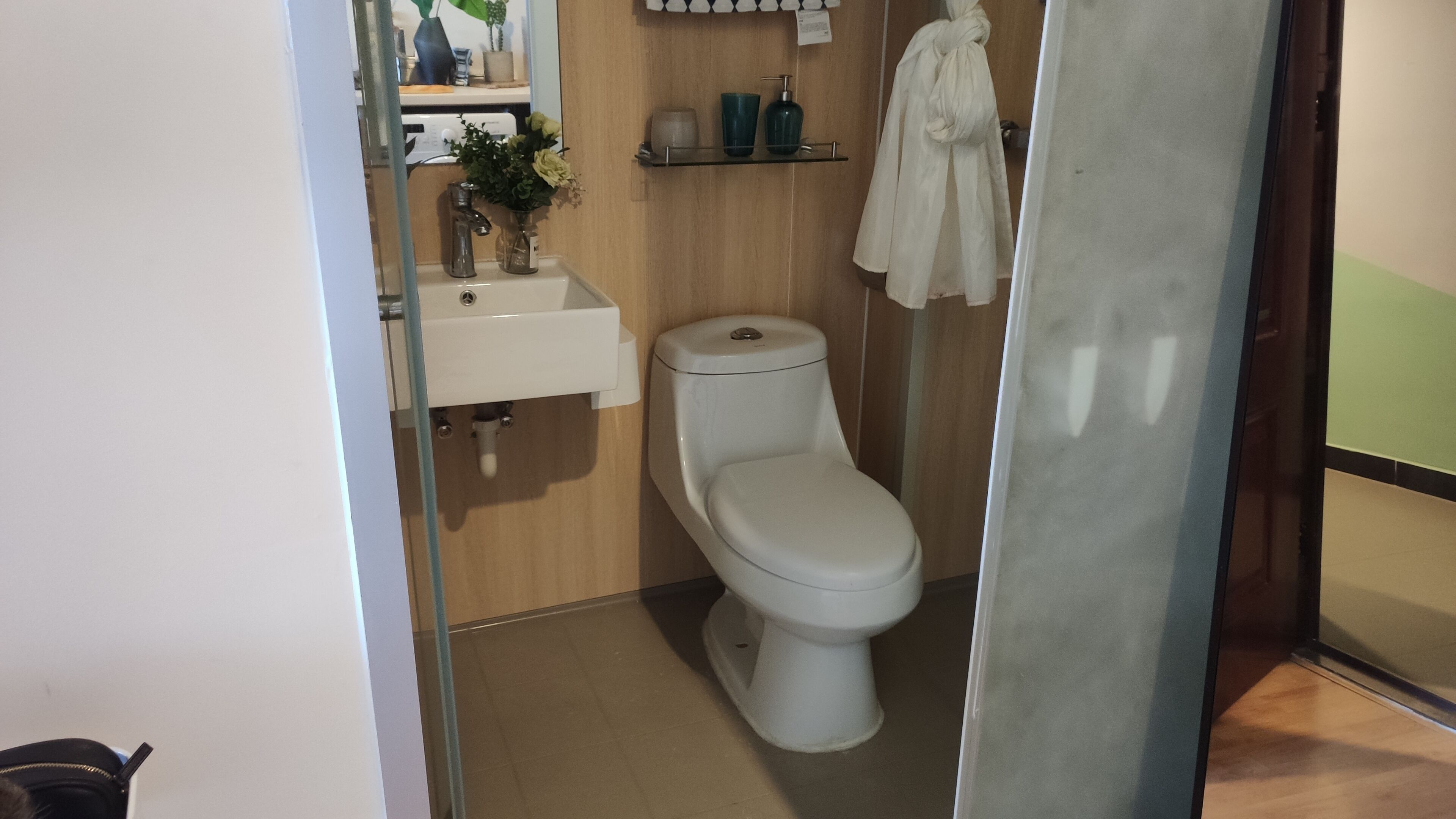 A modern bathroom with a toilet, sink, and a mirror.