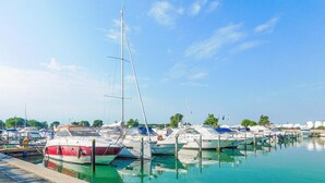 A marina with various boats docked, calm water, and a clear sky. - 1 bedroom stunning apartment in Caorle (Caorle)