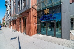 A modern building with a prominent 'GRANO RESIDENCE' sign, featuring a glass facade and a brick exterior. - Apartment in the Center (Gdansk)