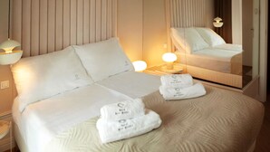 A neatly made bed with white linens, a bedside lamp, and a folded towel on the bed. - Apartment in the Center (Gdansk)