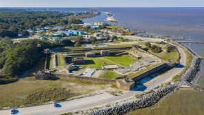An aerial view of a coastal fort with a surrounding road and buildings. - Dauphin Island's East End Jewl (Dauphin Island)