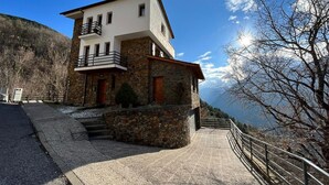 A modern two-story building with a stone facade, a balcony, and a view of a mountainous landscape. - Spacious house (sleeps 7) with incredible view HUT6007971 (Aubinyà)
