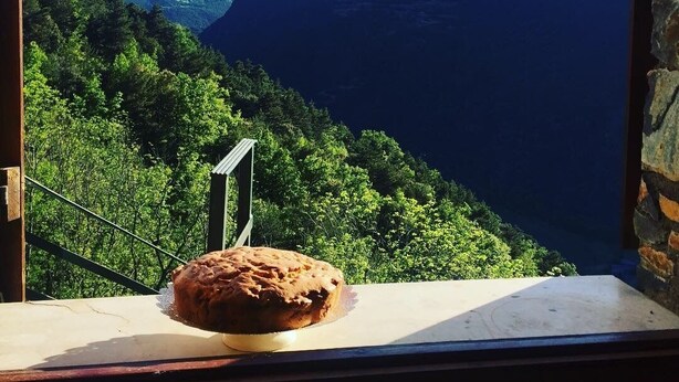 A loaf of bread on a table with a view of a mountainous landscape. - Spacious house (sleeps 7) with incredible view HUT6007971 (Aubinyà)