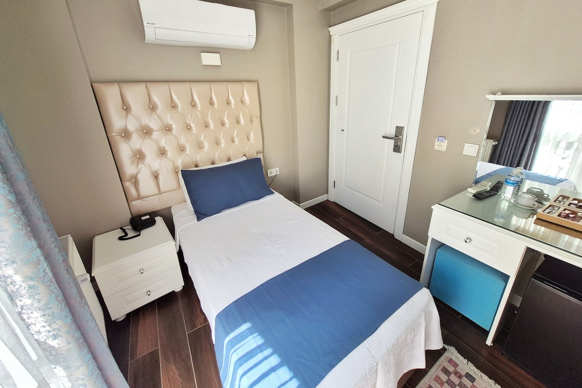 Une chambre d’hôtel comprenant un lit, une table de chevet, une commode, un bureau et un miroir.