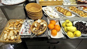 A buffet table with various food items, including bread, pastries, fruits, and condiments. - Cape Palace Hotel (Istanbul)