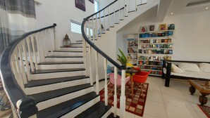 A staircase with black and white railings leading to a landing. - Butterfly House (Malindi)