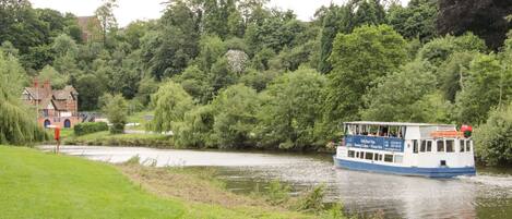 A river with a boat and a building in the background.