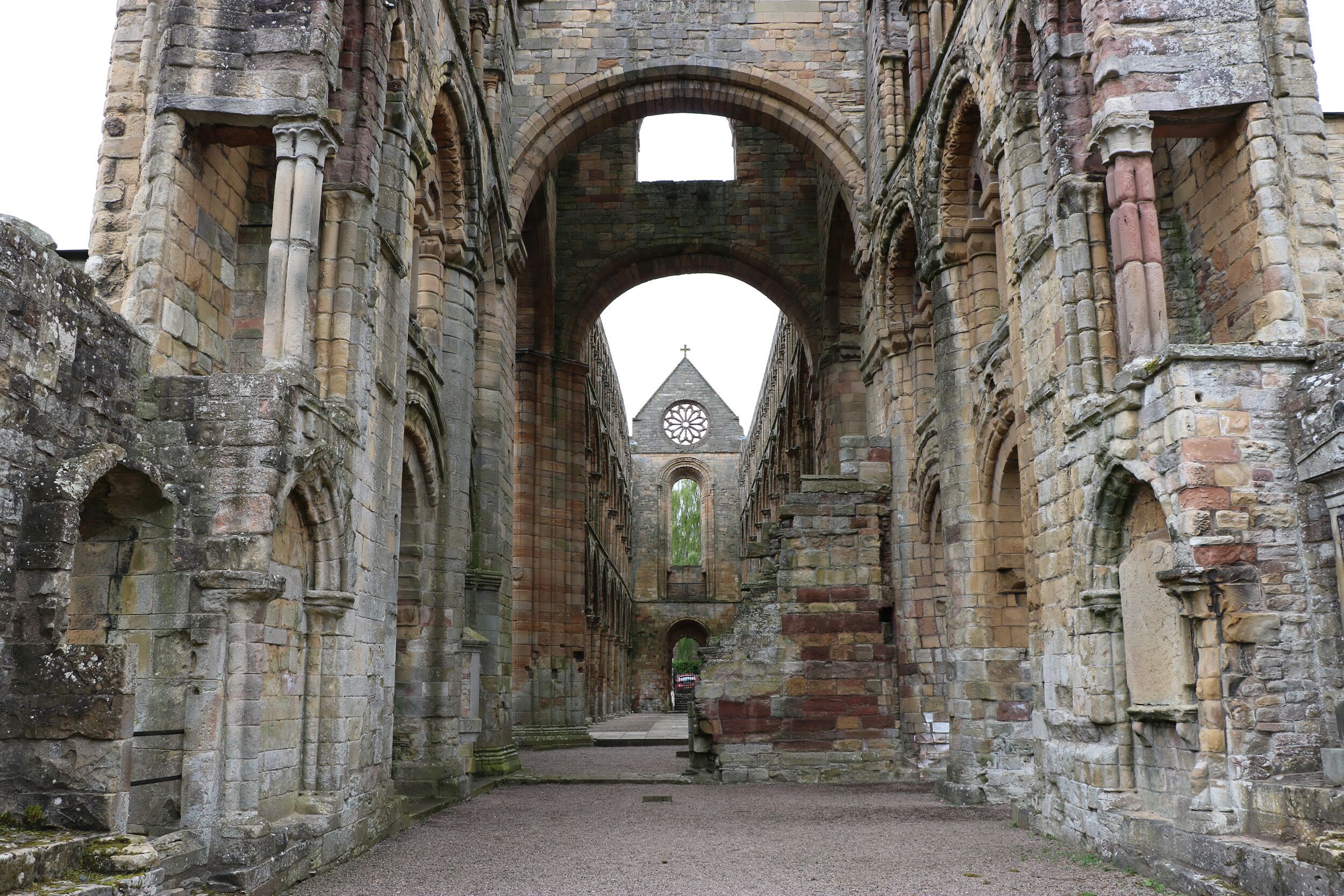 An ancient stone structure with arched passageways and a central tower with a circular window.