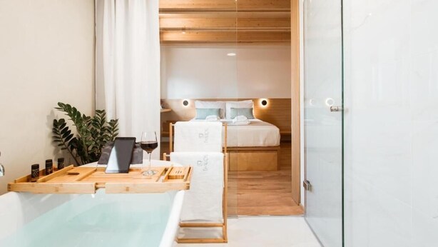 A modern bathroom with a glass shower enclosure, a wooden vanity, and a bathtub. - Thallos the Boutique (Chania)