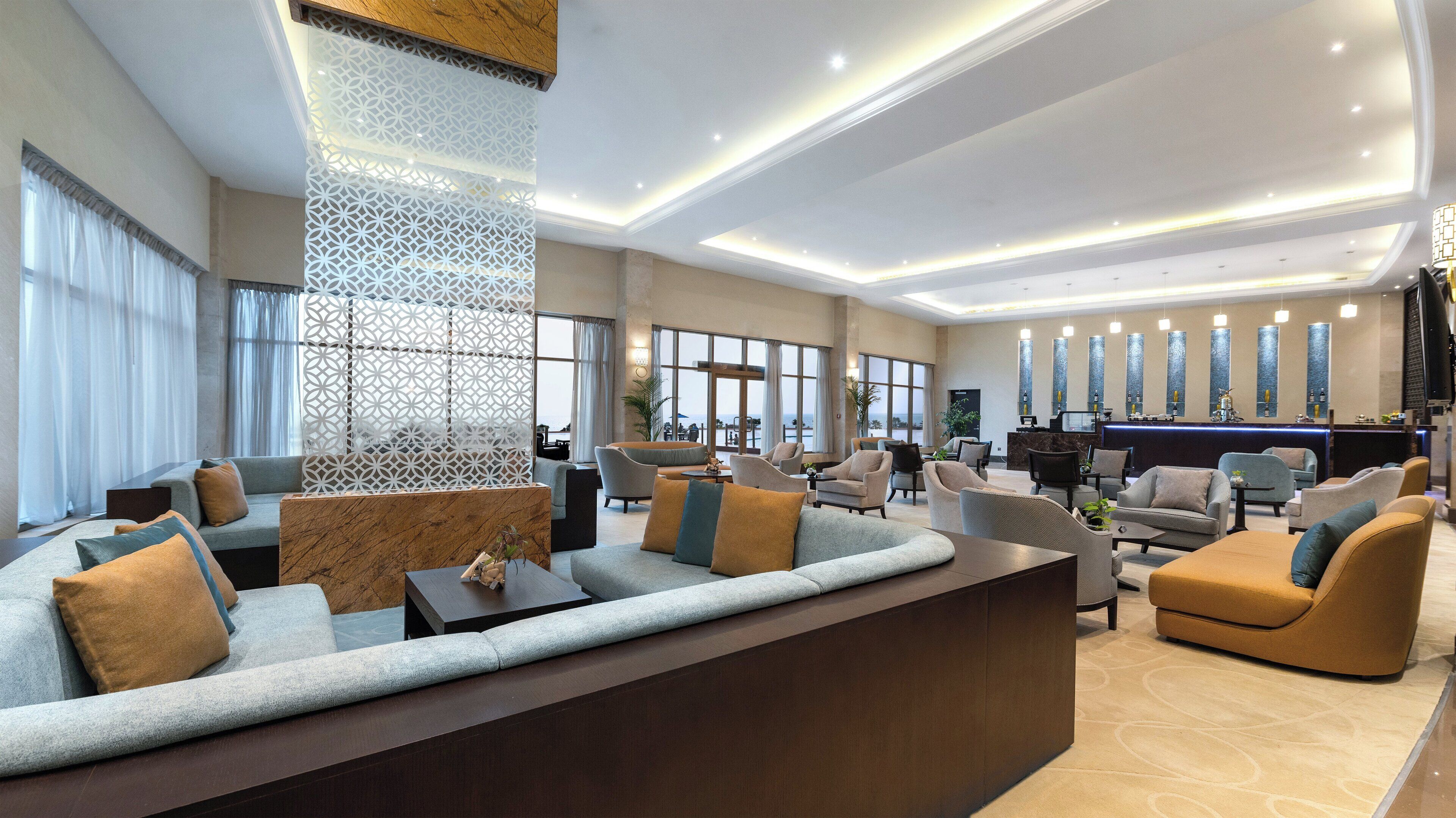 A modern lobby with a reception desk, seating area, and large windows offering views.