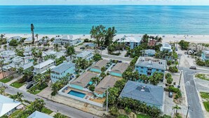 Un área residencial costera con casas, una playa y una vista despejada del océano.
