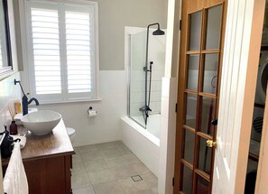 Bathtub, hair dryer, towels, shampoo