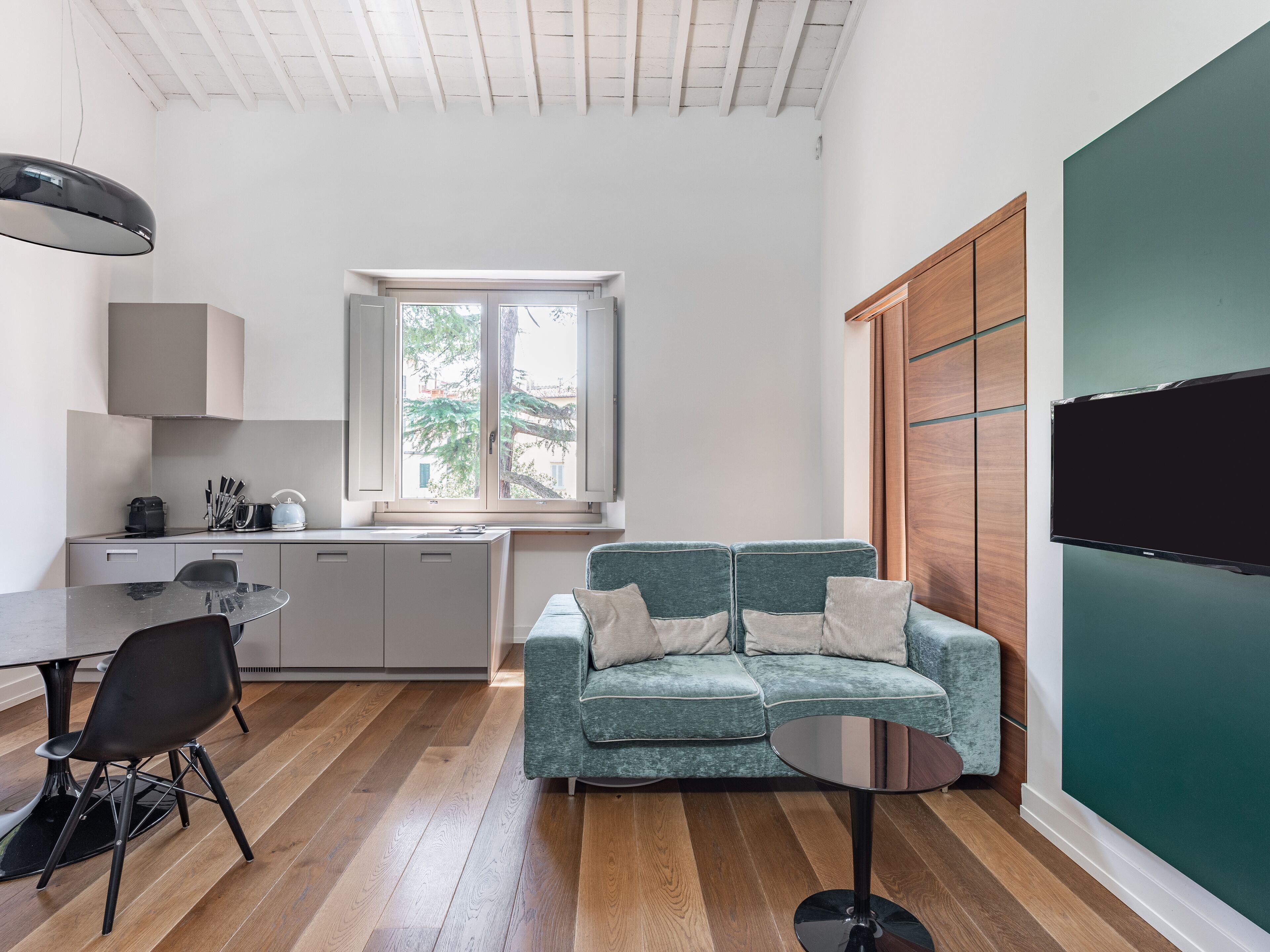 Una cocina moderna con una mesa de comedor, un sofá y un televisor.