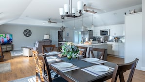 A modern kitchen with white cabinets, a central island, and stainless steel appliances.