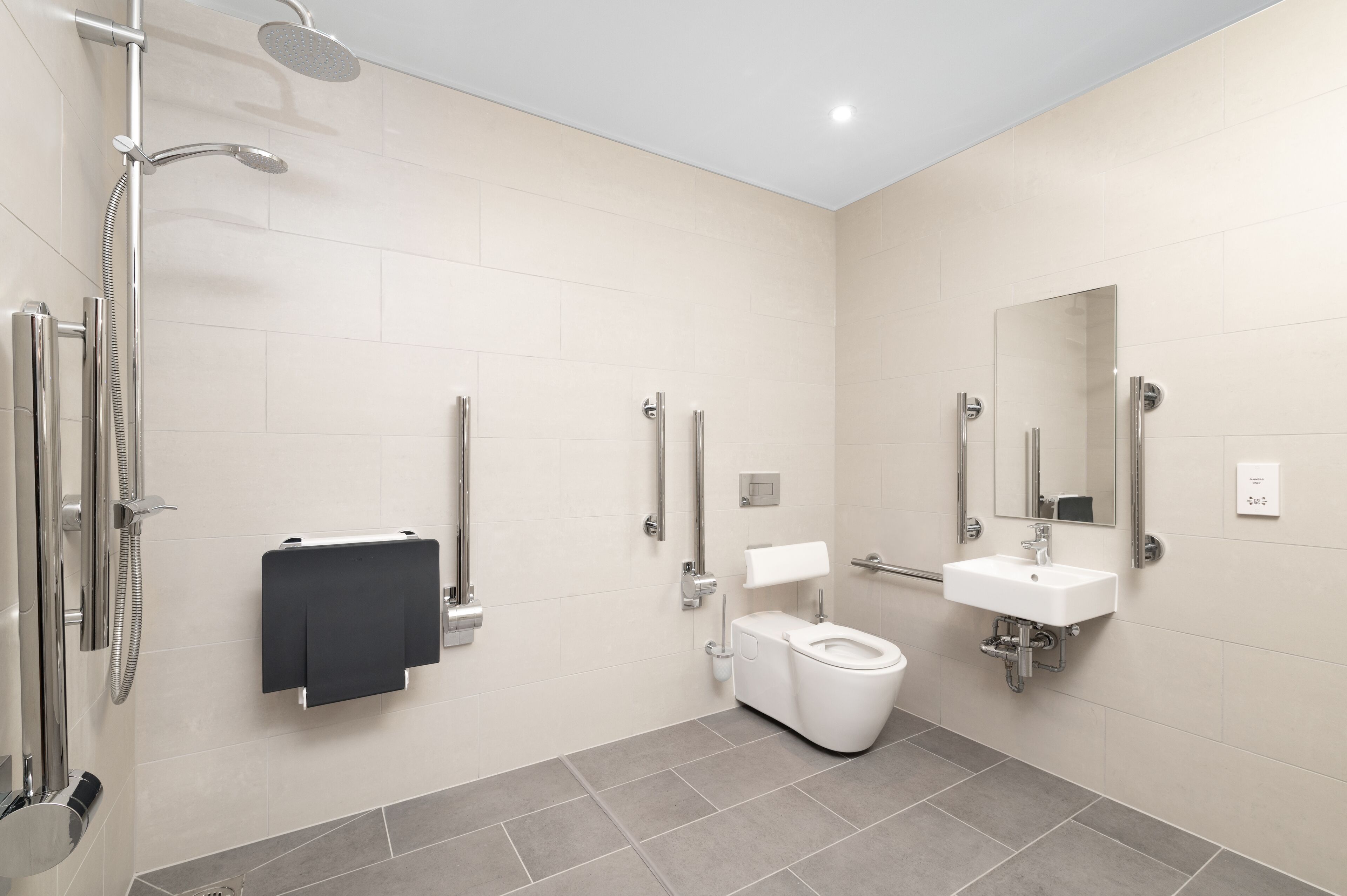 A modern bathroom with a shower, toilet, and sink.