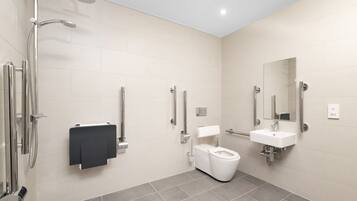 A modern bathroom with a shower, toilet, and sink.