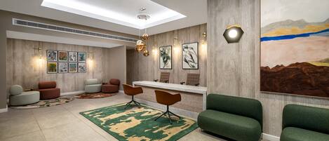 A modern lobby with a skylight, seating area, artwork, and a reception desk.