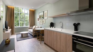 A modern kitchen with a dining area, large windows, and a built-in oven. - The Lincoln Suites (London)