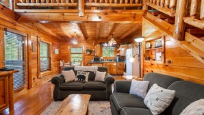 Ein Holzhaus-Interieur mit Wohnzimmer, Küche und Treppe.