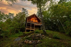 A cabin with a balcony, surrounded by trees and a stone pathway leading to it. - Snuggly Bear Bottom Cabin~2/3 B/B~Hot Tub~Arcade (Sevierville)
